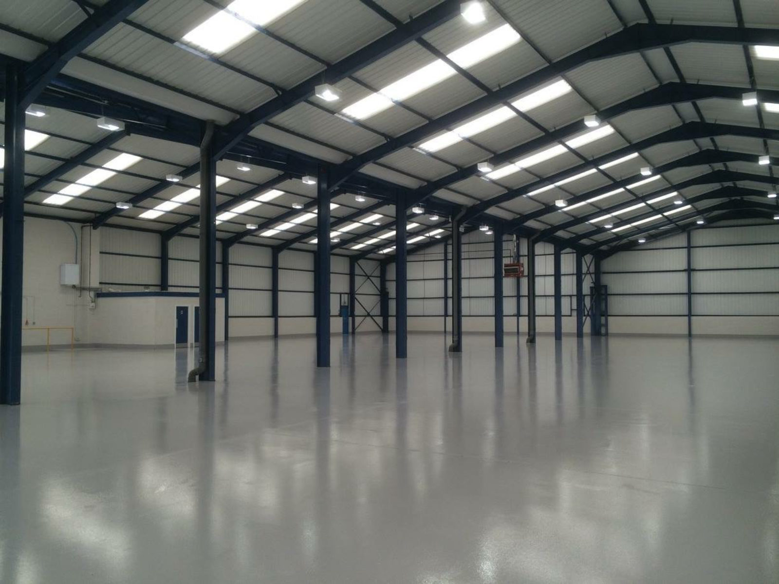 A high-gloss resin floor in a modern steel-framed industrial unit