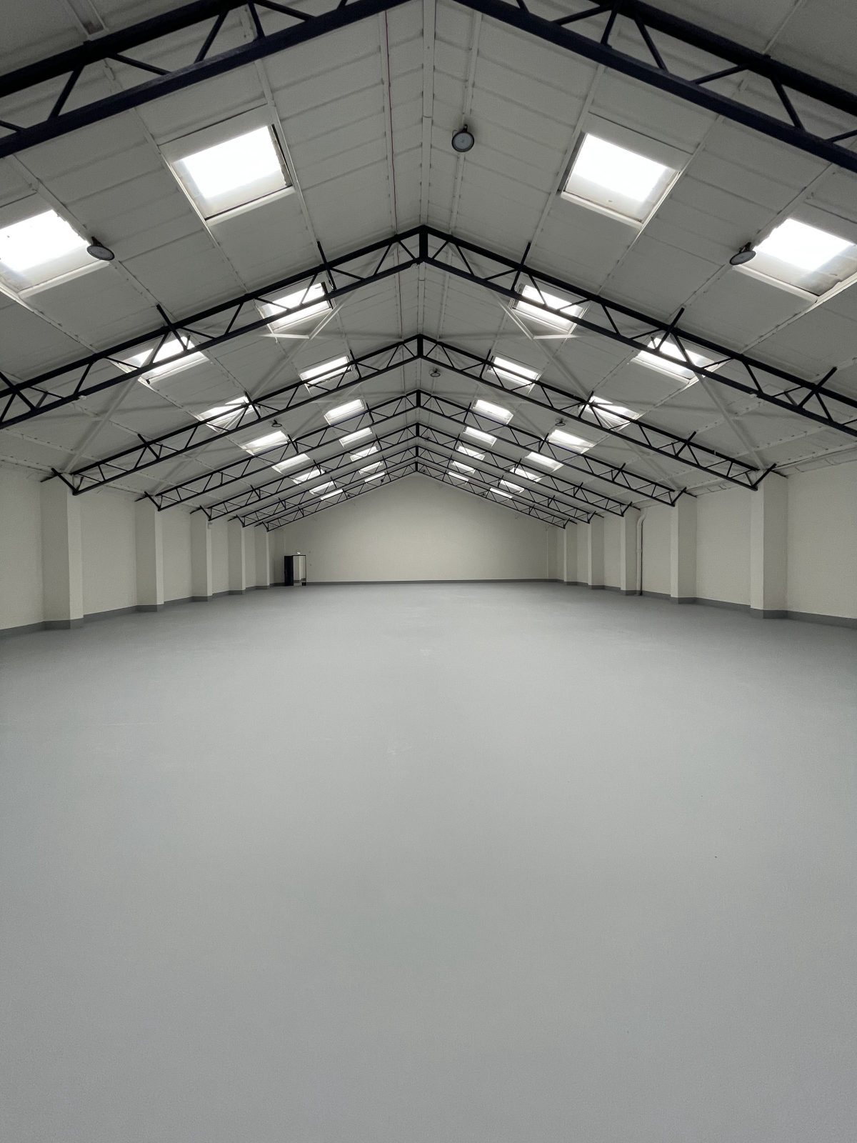 A pristine resin floor in a steel-framed industrial warehouse
